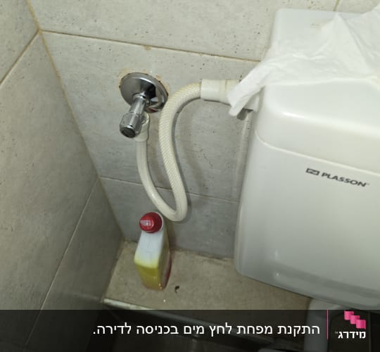אסלה עם צינור מים ובקבוק חומר ניקוי